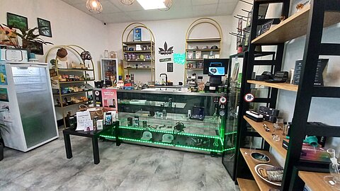 Blick in den Mellow Peaks Botanicals Naturshop im Q24 in Imst mit Verkaufstheke und Regalen.